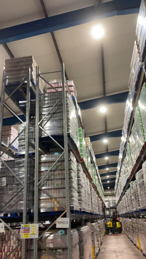 Warehouse aisle with overhead LED lighting installed by Fox Electrical