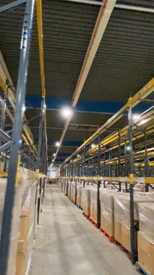 Warehouse racking illuminated by LED panels, industrial lighting project