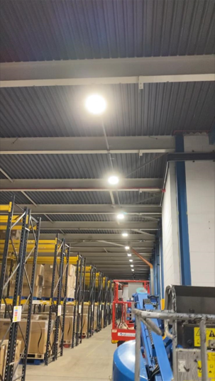 Warehouse ceiling with rows of round LED high-bay fittings